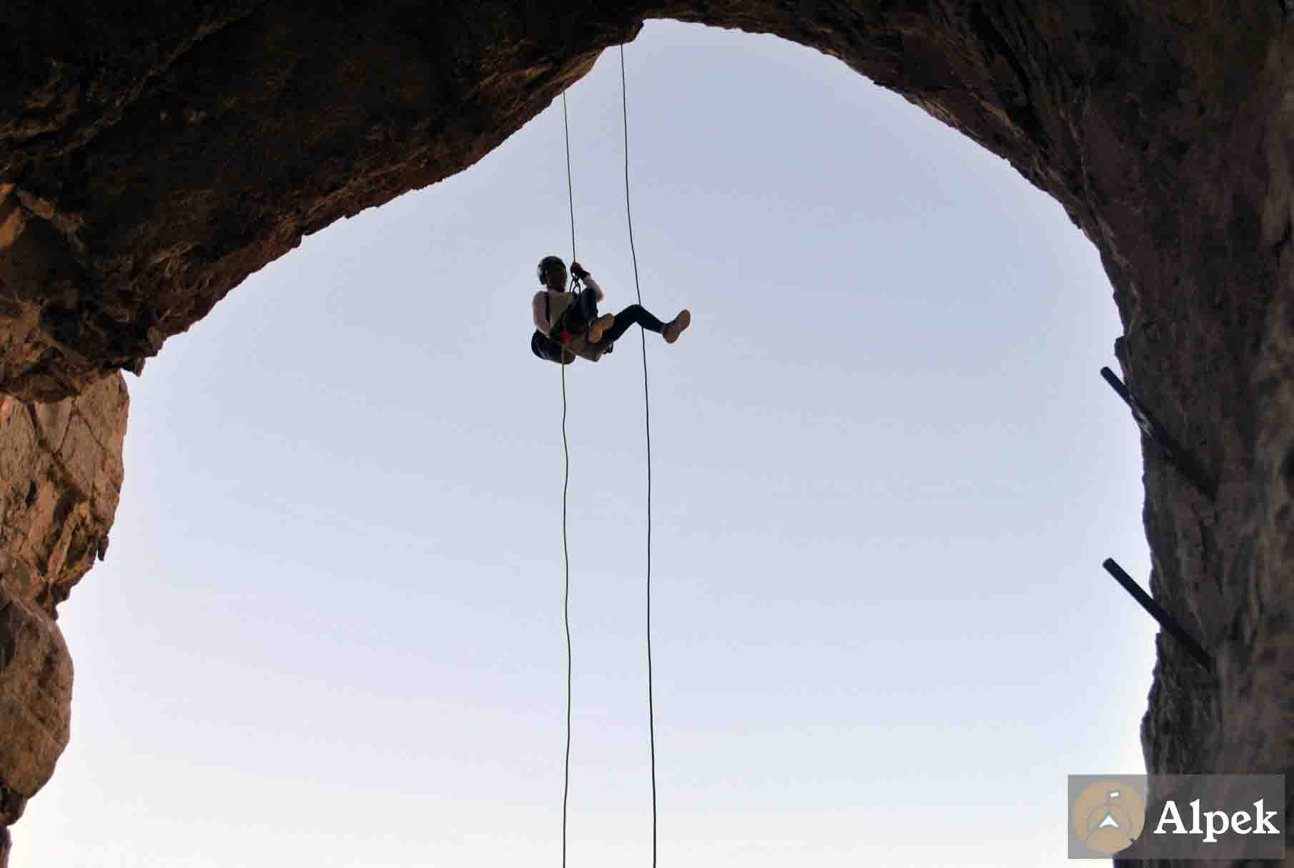 Persona descendiendo en rapel vista desde una cueva